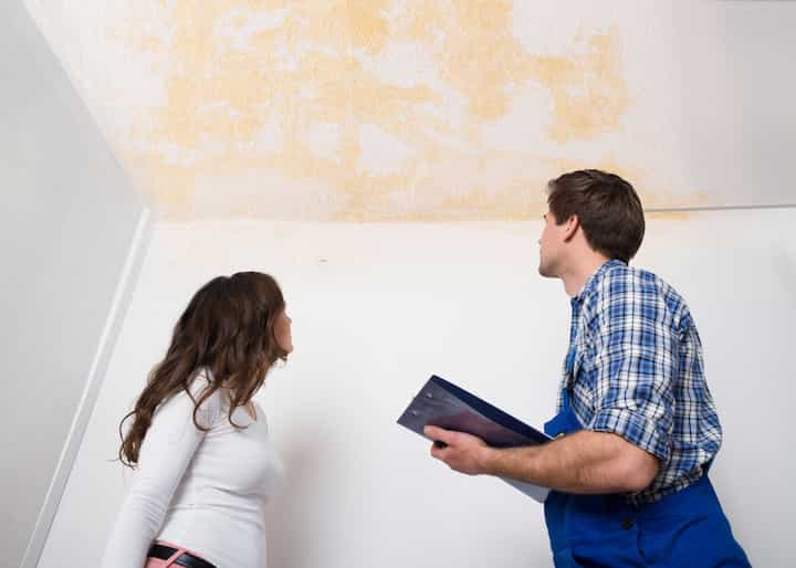 A water damage expert doing an assessment and inspection with a woman who has damaged ceiling caused by a water leak in Augusta, GA